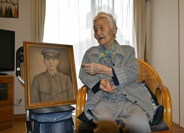 戦死した兄の遺影の横で平和への思いを語る武井さん＝９月上旬、小山市下生井