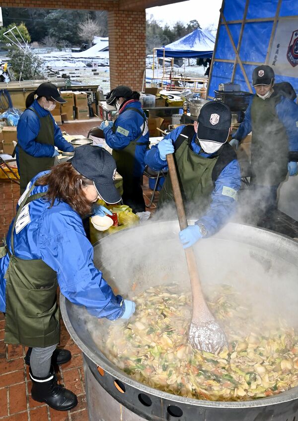 避難所となった小学校で炊き出しをする新潟県のボランティアたち＝15日午後４時40分、石川県珠洲市