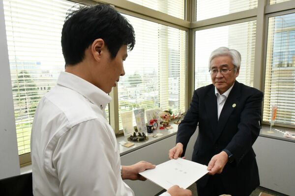 岩佐景一郎県保健福祉部長(左)に消化器外科医確保に向けた要望書を提出する日本臨床外科学会の尾澤県支部長=9月、県庁