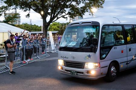 　国立競技場へ向け、メインのサブトラックを出発する選手を乗せたバス＝２１日午後、東京都渋谷区