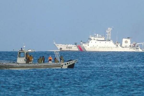 南シナ海・南沙諸島のパグアサ島沖をパトロールするフィリピン海兵隊のボート(手前)。中国海警局の艦船が見える=5月3日(ゲッティ=共同)
