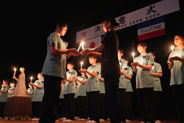 キャンドルに火をともす看護学生ら