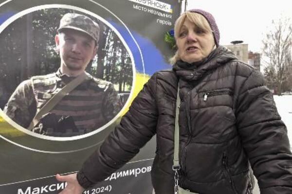 息子の遺影の前で話すナタリア・ネフョードワさん。ロシアのウクライナ侵攻開始から24日で4年となった=23日、ウクライナ・スラビャンスク(共同)