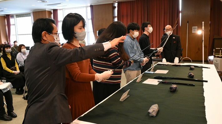 真剣な表情で刀剣を見つめる参加者