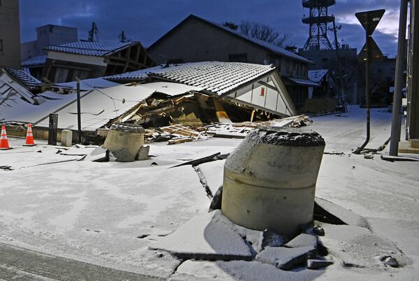 路面から突き出たマンホール。液状化の影響とみられる＝14日午前６時40分、石川県輪島市