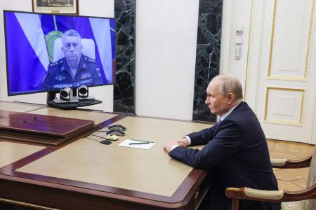 　ロシア軍戦略ミサイル部隊司令官から報告を受けるプーチン大統領＝１２日、モスクワ（タス＝共同）
