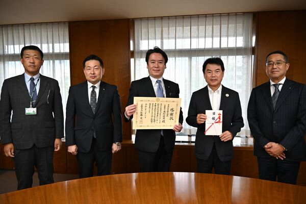 佐藤市長（右から２人目）に目録を贈呈した竹本副社長（中央）