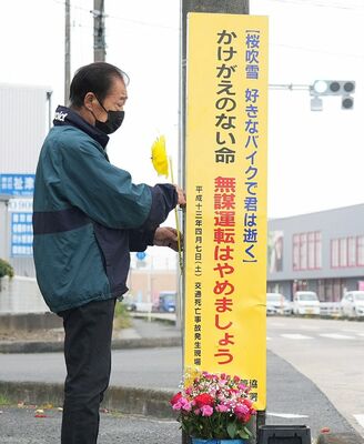 事故現場に黄色い風車を設置する楠野さん