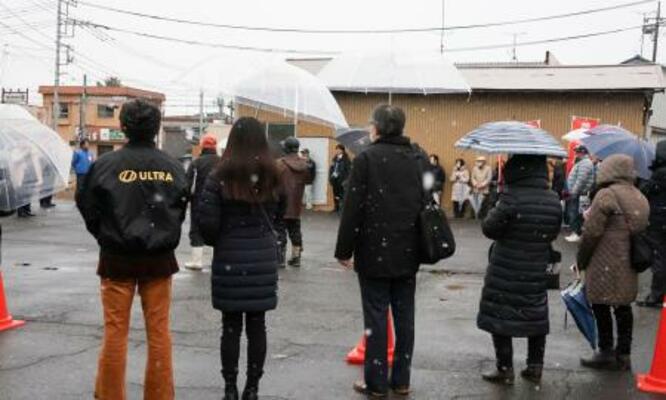 　雪が降る中、候補者の街頭演説に耳を傾ける人たち＝７日午後、茨城県行方市