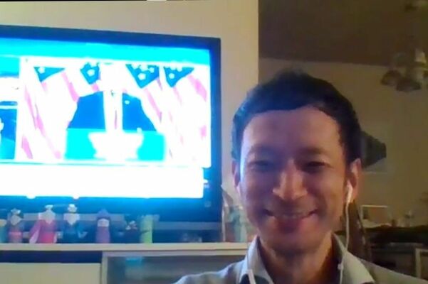 米大統領選を報じるテレビの前でオンライン取材に応じる田崎さん＝７日