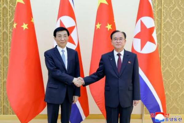 北朝鮮の趙甬元・朝鮮労働党書記(右)と握手する中国共産党序列4位の王滬寧・人民政治協商会議主席=15日、平壌(朝鮮中央通信=共同)
