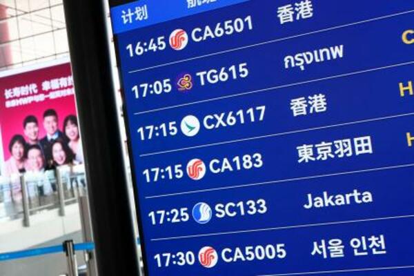 北京首都国際空港の出発ロビーで羽田空港行きの便が表示された電光掲示板=16日(共同)