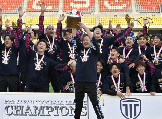 ＪＦＬ初優勝、Ｊ３昇格を決め、トロフィーを手に喜ぶ栃木シティの大栗社長（中央）と選手たち＝11月17日、カンセキスタジアムとちぎ