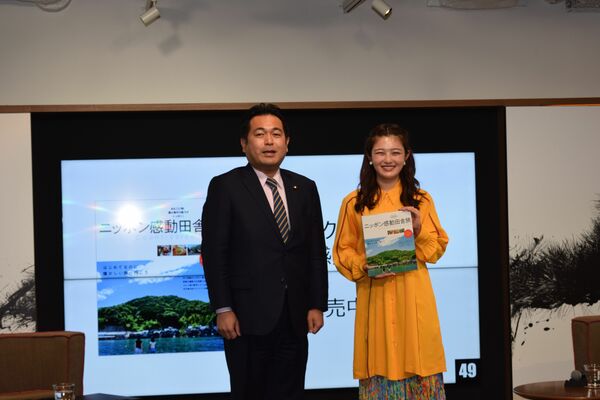 農泊のガイドブックを手にする井上さん（右）と野中農水副大臣＝27日午後、東京・代官山