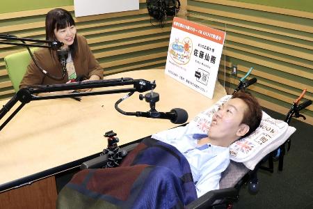 　ＦＭ番組「寝たきり社長のおはようエール」の収録に臨むパーソナリティーの佐藤仙務さん（右）＝５月、名古屋市
