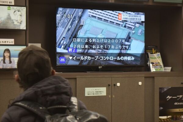 日銀のマイナス金利政策解除のニュースを見る来庁者＝19日午後、宇都宮市役所
