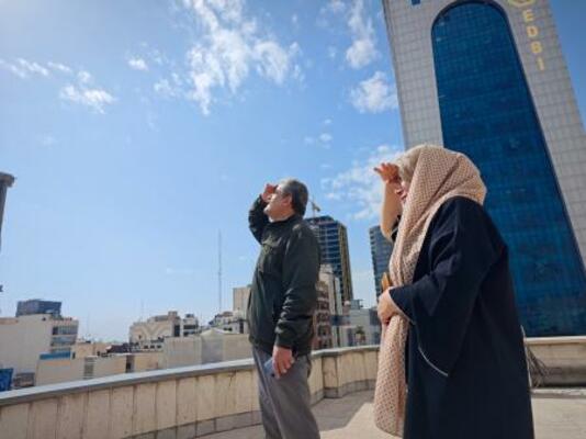 　イランの首都テヘランで建物の屋上から空を見上げる人たち＝２８日（ゲッティ＝共同）