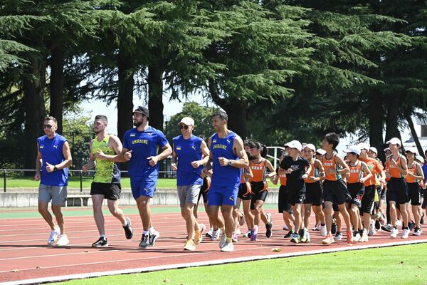 ４００メートルトラックを走るウクライナ選手団と子どもたち