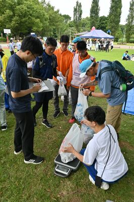 集めたごみを計量する参加者ら