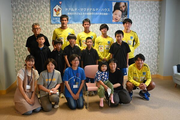 栃木ＳＣの選手らと記念撮影をする子どもたち