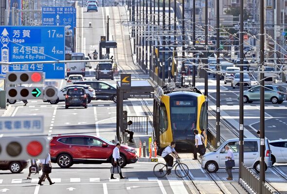 朝の通勤時間帯に人や車が行き交う鬼怒通りを走行するＬＲＴ＝25日午前８時45分、宇都宮市宮みらい
