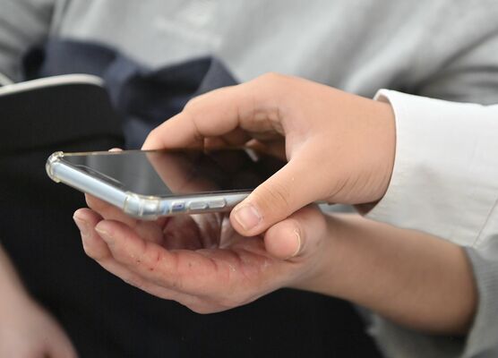 借りていたスマートフォンを陽佳さんの手のひらに置き、返す優君。家事をこなす陽佳さんの手にはひび割れが目立つ＝１月上旬