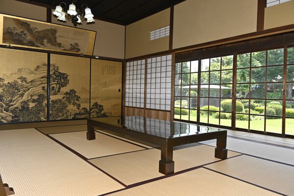 部屋からガラス戸越しに望む美しい庭園風景
