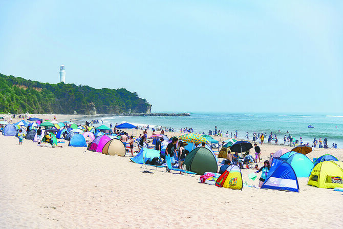 久慈浜海水浴場。白い灯台と広い砂浜、遠浅の海が特徴（提供写真）