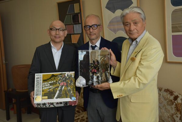 福田知事（右）にガンプラを贈る森安さん（左）ら＝７日午後、県庁