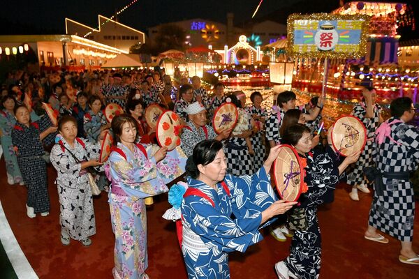 きらびやかな電飾の中、４年ぶりに日光和楽踊りを披露する参加者たち＝４日午後７時15分、日光市清滝町