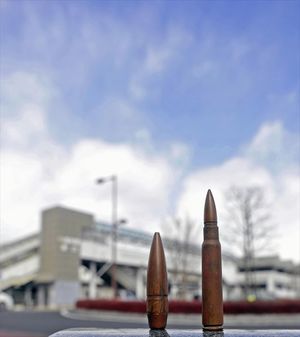 小金井空襲で、小金井駅前の旅館に打ち込まれた米軍機の銃弾（下野市小金井、山中征男さん所有）。建物１階の押し入れの布団の中で見つかったという。背景は現在のＪＲ小金井駅