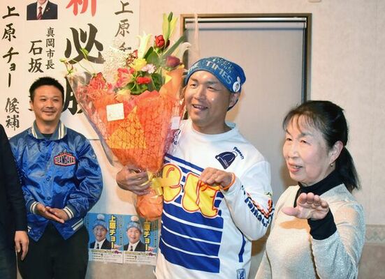 初当選を決め、母ミサトさんとポーズを取る上原亮氏（中央）＝４月