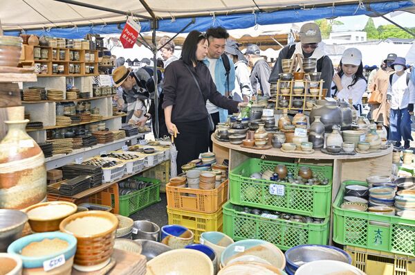 所狭しと並んだ陶器を品定めする来場者＝29日午前、益子町益子