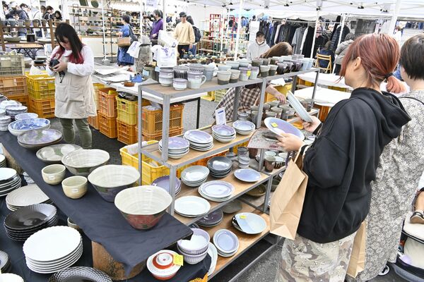 陶器を手に取って品定めする来場者