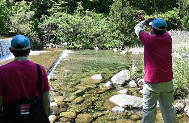 対岸に向かって注意する職員