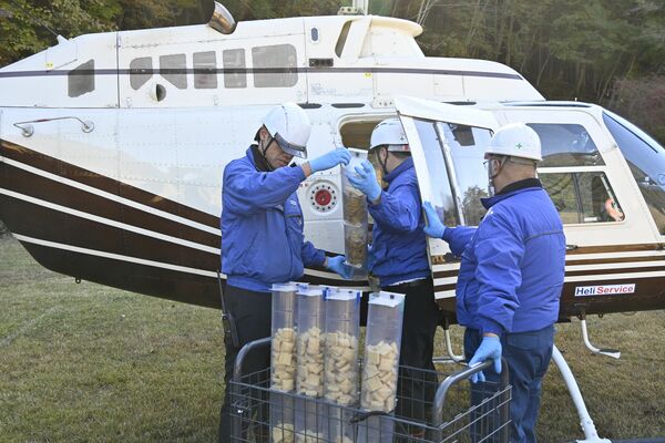 散布する経口ワクチンをヘリコプターに積み込む作業員＝４日午前、日光市