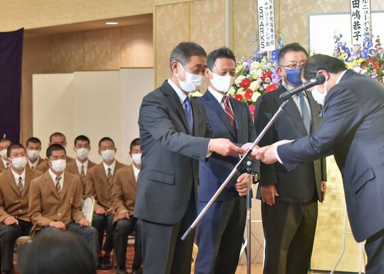 壇上で感謝状を受け取る作新高の指導者陣＝宇都宮市内