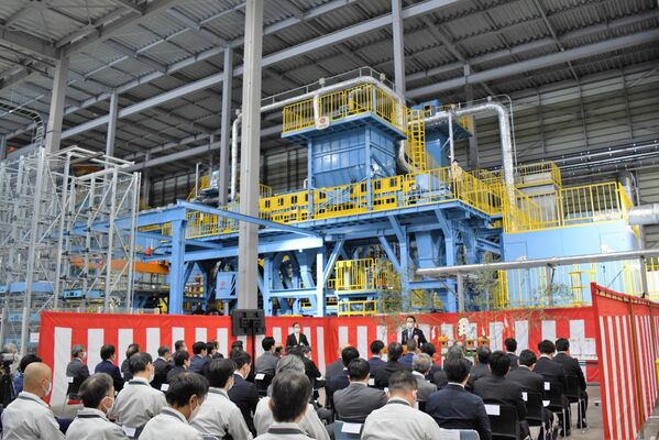 生産ラインの鋳造設備前で行われた竣工式＝18日午前、足利市