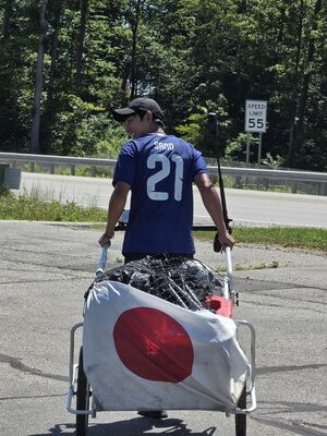 サムライブルーのユニホーム姿で旅を続ける男性=4日、ウェストバージニア州パーカーズバーグ付近