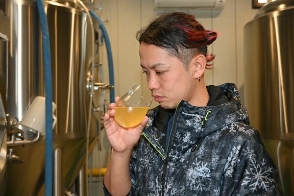 「日本」をイメージした「世界を旅するカントリービール」の香りを確かめる小野崎さん＝小山市