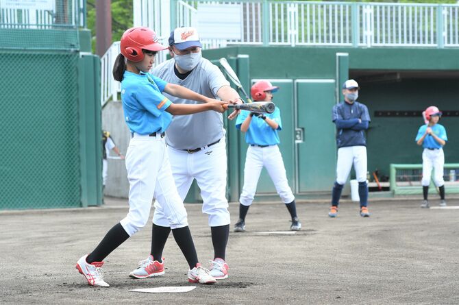 大会に向けて、コーチの指導を受けながら打撃練習に励む選手たち（日光運動公園野球場）