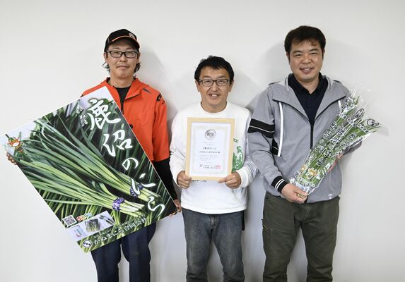 銀賞になった「鹿沼のにら」と、賞状を持つ山崎社長（中央）ら