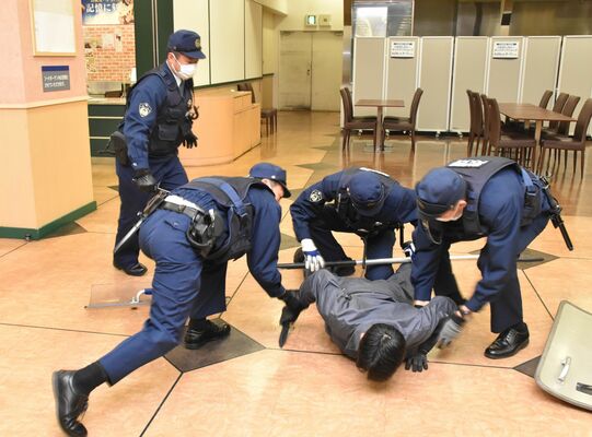 警察官に取り押さえられる犯人役