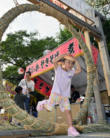 楽しそうに茅の輪をくぐる子ども=30日午後5時15分、茂木町茂木
