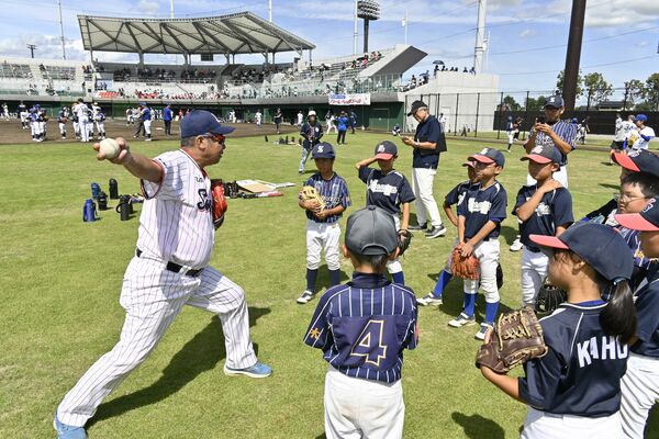 元ヤクルトの飯田さん(左)から直接指導を受ける子どもたち