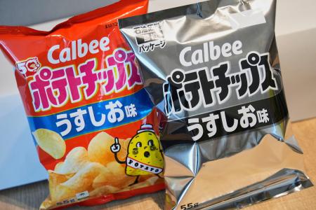 　ナフサの不足を受け、白と黒の２色に変更されたカルビー「ポテトチップス」の包装（右）と従来の商品＝１４日、東京都内（ＡＰ＝共同）