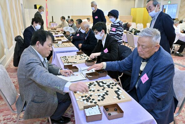 プロ棋士（左）と対局する囲碁ファン