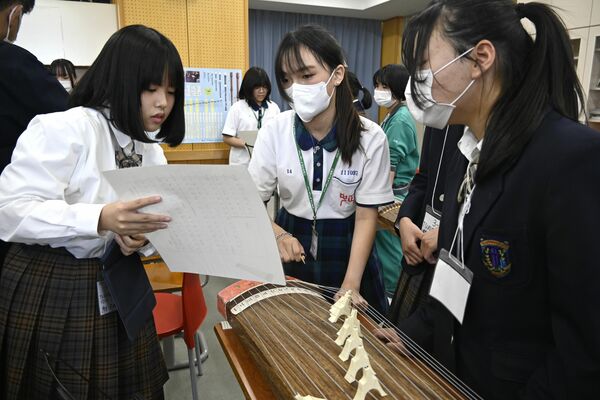 中正国民中の生徒（中央）らと琴の演奏に取り組む様子