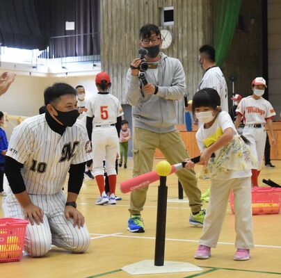 ティーを使った打撃練習をサポートする澤井さん（左）