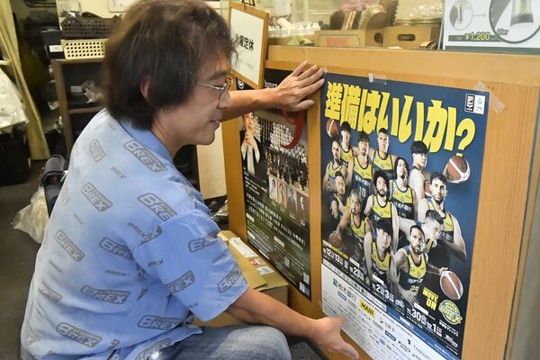 オリオン通り周辺の店舗にポスターを張る参加者